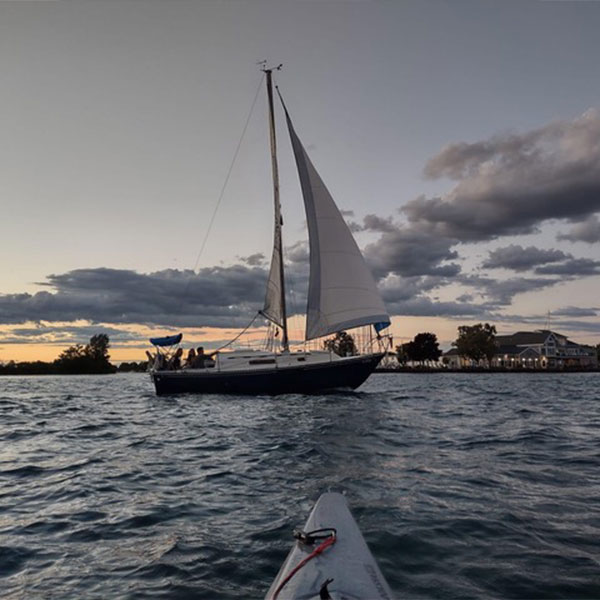 photo of a sailing boat from a kayak on a cloudy day