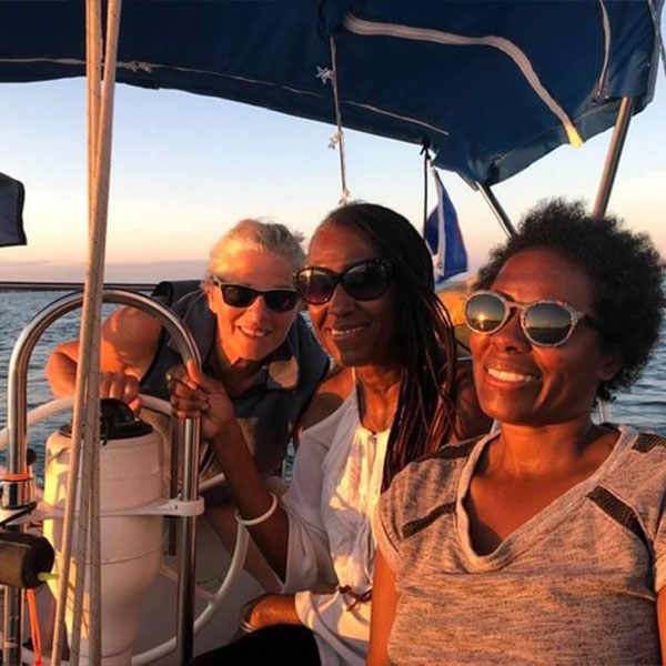older ladies smiling and posing for a photo on a sunset cruise